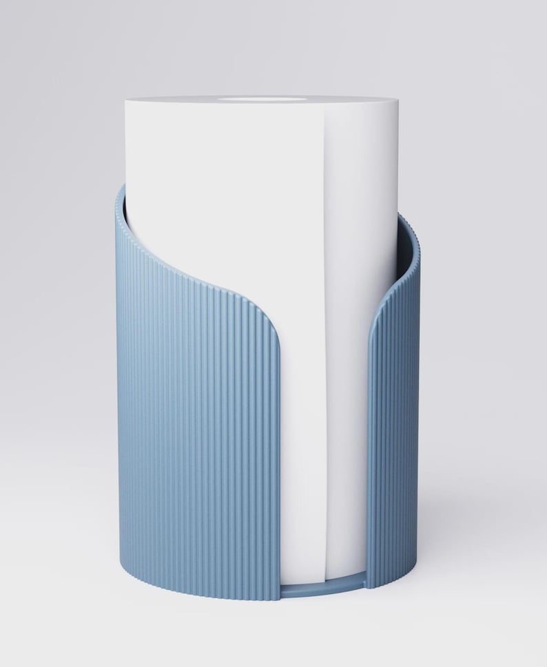 May include: A light blue, cylindrical paper towel holder with vertical ribbed detailing. The holder has a curved opening and holds a roll of white paper towels. The design is modern and minimalist.