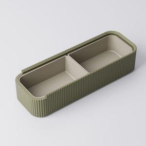 Peut inclure: Un r&eacute;cipient de rangement rectangulaire vert olive avec un ext&eacute;rieur nervur&eacute; et deux compartiments int&eacute;rieurs. L'int&eacute;rieur est de couleur beige clair. Le r&eacute;cipient est con&ccedil;u avec un couvercle qui s'adapte parfaitement.