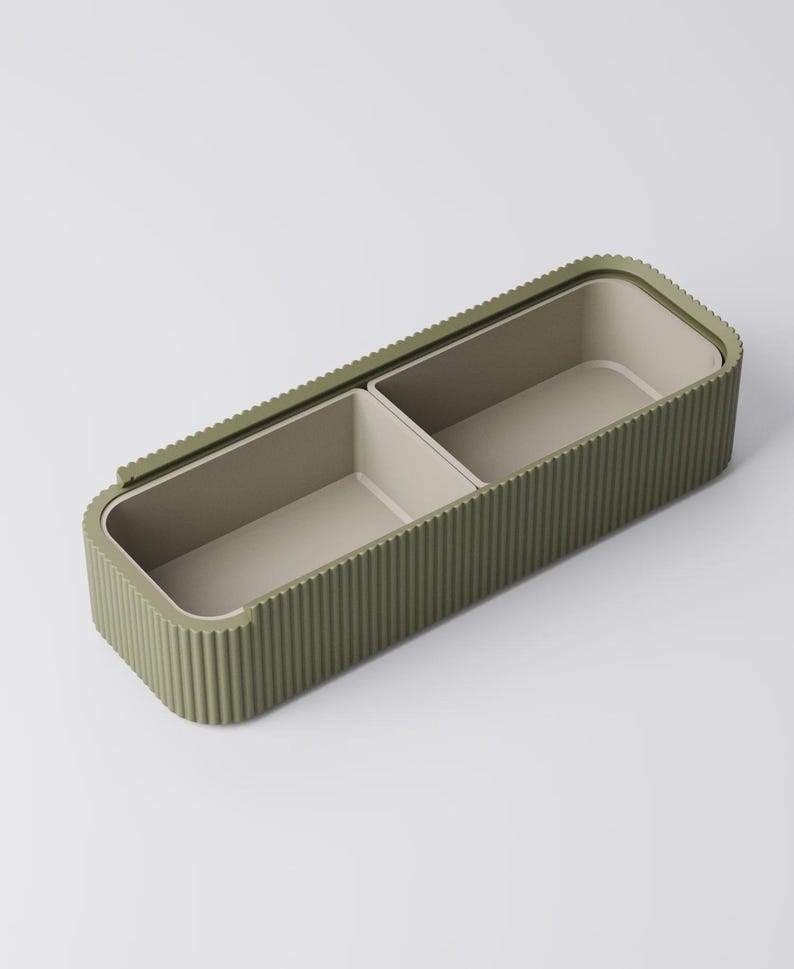 Peut inclure: Un r&eacute;cipient de rangement rectangulaire vert olive avec un ext&eacute;rieur nervur&eacute; et deux compartiments int&eacute;rieurs. L'int&eacute;rieur est de couleur beige clair. Le r&eacute;cipient est con&ccedil;u avec un couvercle qui s'adapte parfaitement.