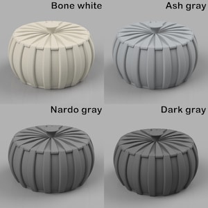 Puede incluir: Cuatro pufs decorativos en blanco hueso, gris ceniza, gris Nardo y gris oscuro. Cada puf tiene forma redonda con laterales acanalados verticales y una parte superior circular con un bot&oacute;n central. La imagen muestra los pufs sobre un fondo neutro.