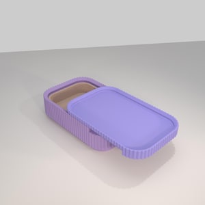 May include: A rectangular, lavender-colored lunch box with a matching lid. The lid is partially open, revealing the interior. The lunch box has a ribbed texture on the sides and lid, and a smooth interior.