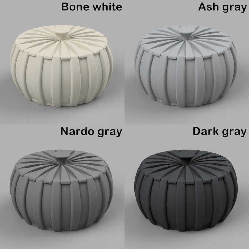 Puede incluir: Cuatro pufs decorativos en blanco hueso, gris ceniza, gris Nardo y gris oscuro. Cada puf tiene forma redonda con detalles acanalados verticales alrededor de los lados y una parte superior circular. Los colores est&aacute;n etiquetados encima de cada puf.
