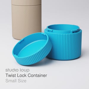 Pode incluir: Um recipiente bege e turquesa com fecho de torção e design canelado. O recipiente turquesa está aberto, revelando o interior. O texto "studio loup Twist Lock Container Small Size" é visível.