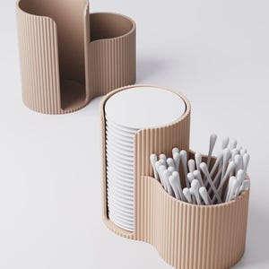 Puede incluir: Organizador beige con textura acanalada y tres compartimentos. Una secci&oacute;n contiene una pila de posavasos blancos, otra bastoncillos de algod&oacute;n y la tercera est&aacute; vac&iacute;a. El dise&ntilde;o es moderno y minimalista.