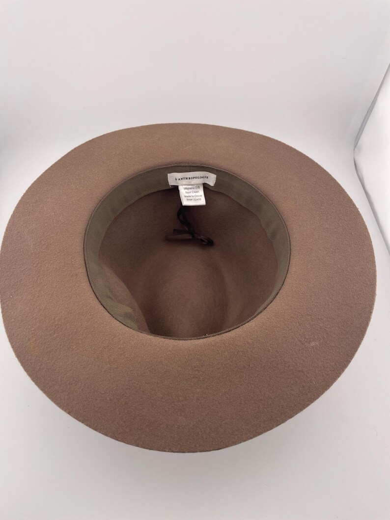 Puede incluir: Sombrero fedora marr&oacute;n con ala ancha. El interior presenta una banda verde oscuro y una etiqueta de marca. El sombrero est&aacute; hecho de un material suave similar al fieltro, ideal para a&ntilde;adir un toque de estilo a cualquier atuendo.