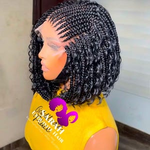 May include: A black braided wig with curly ends is displayed on a mannequin head. The wig features a lace front and is styled with neat cornrows at the front and sides. The mannequin is wearing a yellow shirt with text and a logo.