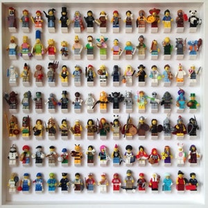 May include: A framed display of over 100 miniature Lego figures, organized in rows. The figures are a variety of colors and designs, including characters from popular movies, TV shows, and video games.