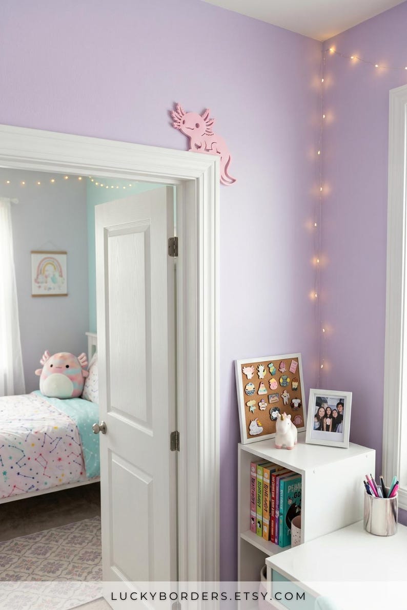 Peut inclure: Int&eacute;rieur de chambre lilas avec une porte blanche et une d&eacute;coration axolotl rose. Une &eacute;tag&egrave;re blanche pr&eacute;sente des livres, une photo encadr&eacute;e et un tableau en li&egrave;ge avec des &eacute;pingles. Le texte "LUCKYBORDERS.ETSY.COM" est visible en bas.