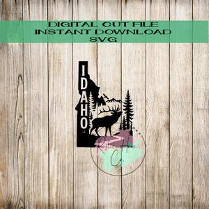 May include: Black digital cut file featuring the outline of Idaho with a silhouette of a deer, mountains, and trees. The word "IDAHO" is vertically stacked. Text at the top reads "DIGITAL CUT FILE INSTANT DOWNLOAD SVG".