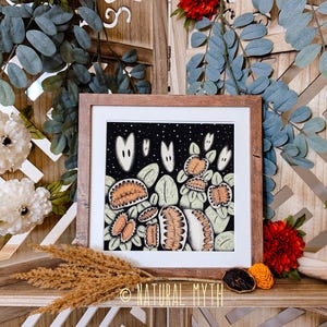 May include: A framed illustration of a dark night sky with white ghosts and orange and green flowers. The text "NATURAL MYTH" is printed in the bottom right corner of the image.