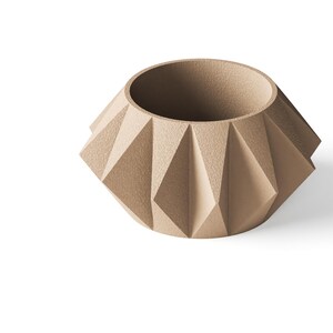 May include: A beige planter with a textured, matte finish and a geometric, faceted exterior. The vessel features a wide, circular opening at the top and a series of triangular, angular panels that create a distinct, multi-sided shape around the body.