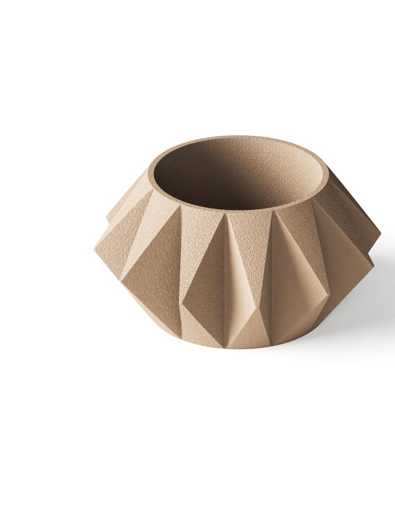 May include: A beige planter with a textured, matte finish and a geometric, faceted exterior. The vessel features a wide, circular opening at the top and a series of triangular, angular panels that create a distinct, multi-sided shape around the body.