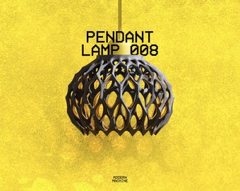 May include: A pendant lamp with a black, intricate, lattice-style shade and a gold-colored interior. The lamp features a gold-colored top fixture and is suspended by a thin rod. The text PENDANT LAMP 008 and MODERN MACHINE is visible.