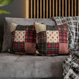 May include: Two square throw pillows featuring a patchwork design of red, green, and cream fabric squares. The pattern includes red and green plaid, red and white gingham, and cream squares decorated with a repeating pattern of small red stars.