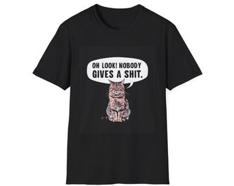 May include: Black t-shirt featuring a graphic of a cat with the text "OH LOOK! NOBODY GIVES A SHIT." The cat is sitting and has brown and gray fur. The text is in a white speech bubble.