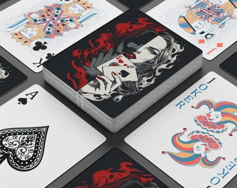 May include: A deck of playing cards with a black and red design featuring a woman holding playing cards. The deck is surrounded by individual playing cards with various suits and face cards. The cards have a dark, gothic aesthetic.