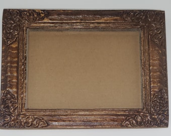 May include: Rectangular brown picture frame with ornate floral corner details. The frame has a distressed finish, with lighter highlights on the raised relief. The center is a light brown color, ready for a photo or artwork.