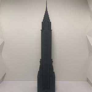 May include: A 3D printed model of the Empire State Building, a famous skyscraper in New York City. The model is made of black plastic and is about 10 inches tall.