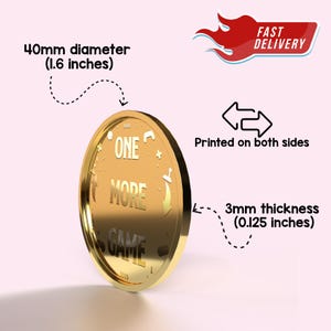 Op de afbeelding: Een goudkleurige munt met de tekst "ONE MORE GAME" en een diameter van 40 mm. De munt is 3 mm dik en aan beide zijden bedrukt. De afbeelding bevat ook de woorden "FAST DELIVERY".