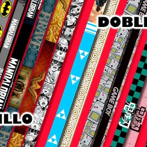 Puede incluir: Una colección de tiras de tela con patrones coloridos con las palabras "Sencillo" y "Doble Vista" impresas en ellas. Las tiras presentan varios diseños, incluyendo patrones geométricos, personajes de dibujos animados y temas de videojuegos.