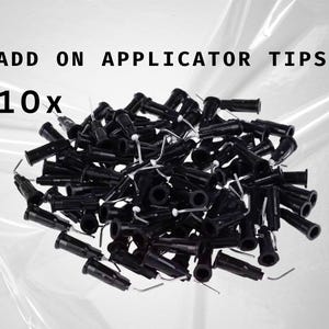 Könnte beinhalten: Ein Nahaufnahmebild von 10 schwarzen Applikatorspitzen. Die Spitzen bestehen aus Kunststoff und haben ein spitzes Ende. Sie werden zum Auftragen verschiedener Flüssigkeiten wie Klebstoff, Farbe oder Harz verwendet.
