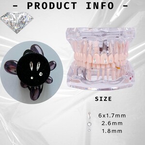 May include: A set of three silver tooth gems in different sizes. The gems are shown on a black velvet background and on a model of a human mouth. The sizes of the gems are 6x1.7 mm, 2.6 mm, and 1.8 mm.