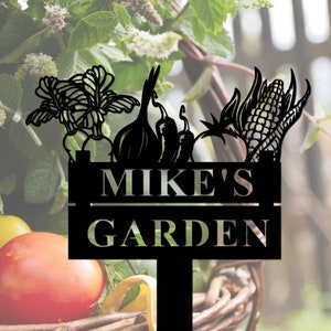 May include: Black metal garden sign featuring a silhouette of vegetables, including corn, onions, peppers, and a leafy green. The sign reads "Mike's Garden".