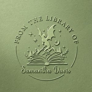 Peut inclure: Un tampon circulaire vert sauge représentant un livre ouvert avec un dragon s'élevant des pages, entouré de montagnes, d'arbres, d'étoiles et d'un croissant de lune. Le texte indique FROM THE LIBRARY OF Samantha Davis en cercle.