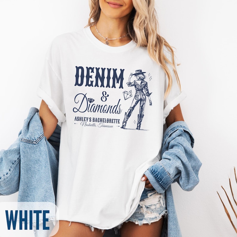 Puede incluir: Camiseta blanca con un dise&ntilde;o gr&aacute;fico azul que dice "Denim & Diamonds" con un dibujo de una mujer con un sombrero de vaquero y botas. El texto tambi&eacute;n dice "Ashley's Bachelorette - Nashville, Tennessee".