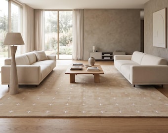 May include: A large rectangular area rug in a soft beige tone featuring a repeating grid pattern of small white cross-shaped accents. The rug is positioned on a light-colored wooden floor, extending across the center of the room.