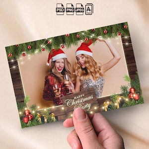 May include: A Christmas party invitation card. It features two women in Santa hats, holding champagne glasses. The card has a wooden frame with festive decorations, including garland, lights, and baubles. The text "Happy Christmas Party" is visible.