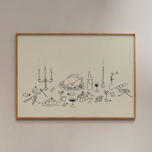 Op de afbeelding: Een ingelijste illustratie met een Thanksgiving-dinersc&egrave;ne. De zwart-wit tekening toont een gebraden kalkoen, wijnflessen, glazen, een kandelaar en andere feestelijke elementen. Het kunstwerk wordt weergegeven in een houten lijst.