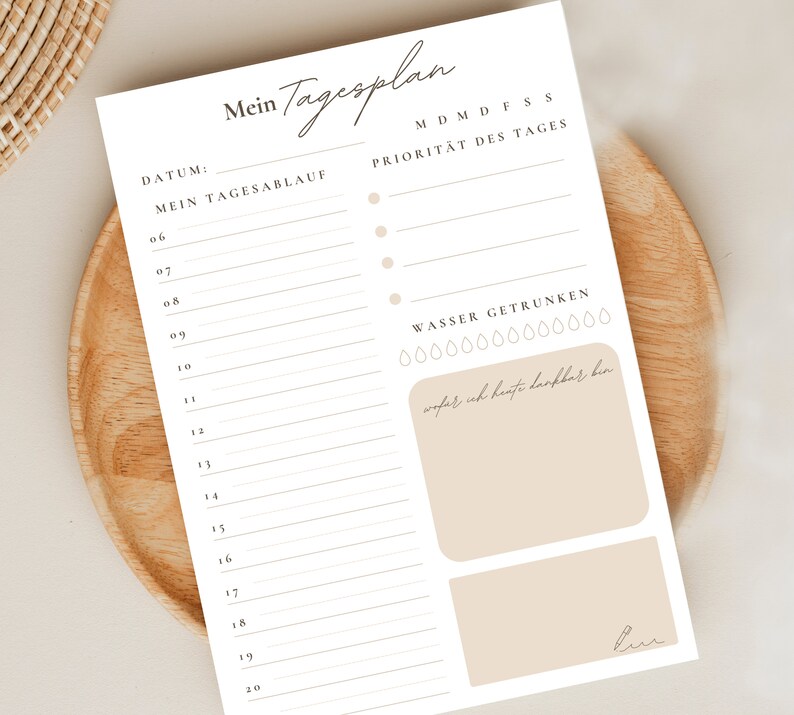 May include: A printable daily planner in white with a beige background. The planner has a section for the date, a section for daily tasks, a section for priorities, and a section for tracking water intake. The planner also has a section for writing down things you are grateful for.