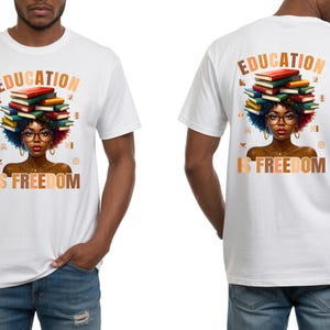 May include: White t-shirt featuring a graphic of a woman with a stack of books on her head, glasses, and the text "EDUCATION IS FREEDOM." The design is repeated on the back. The shirt is a short-sleeved crew neck.