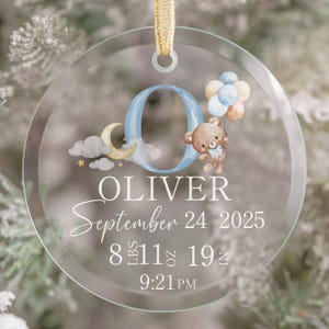 Pu&ograve; includere: Ornamento rotondo e trasparente con un nastro dorato. L'ornamento presenta il nome "OLIVER", la data di nascita, il peso (3,9 kg) e la lunghezza (48 cm). Una "O" blu &egrave; decorata con un orsetto che tiene dei palloncini, una luna e delle nuvole.