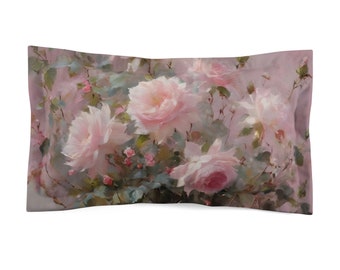 Puede incluir: Una funda de almohada rectangular con un diseño floral de rosas rosas pálidas y hojas verdes. La obra de arte tiene un estilo pictórico con una paleta de colores apagados, creando una estética romántica y vintage. La funda de almohada es probablemente de tela suave.