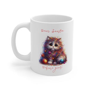 May include: White ceramic mug with a festive design. It features a fluffy cat covered in colourful yarn and baubles, with the text "Dear Santa Define good!" in red script. The mug has a curved handle.