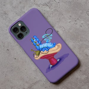 以下が含まれることがあります： アリス・イン・ワンダーランドの毛虫がキノコの上で水タバコを吸っているという漫画のイラストが描かれた紫色の携帯電話ケースです。