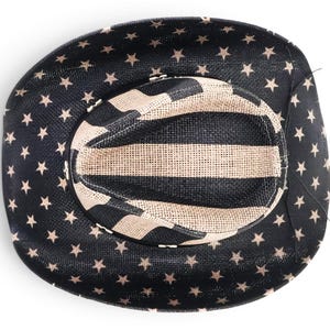 May include: A black cowboy hat with a star pattern on the brim and a striped pattern on the crown. The hat is made of woven material and has a classic western design.