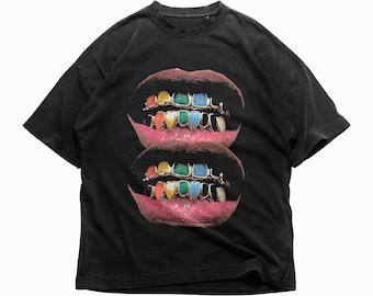 May include: Black t-shirt with a graphic print of two sets of lips with gold teeth and colorful gems.
