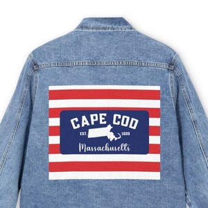 May include: A blue denim jacket with a red, white and blue patch on the back. The patch features a white silhouette of the state of Massachusetts, the text "Cape Cod", "Est. 1620", and "Massachusetts".