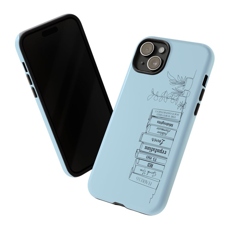 May include: A light blue phone case with a black outline and a stack of books with titles like "Fearless", "Speak Now", "Red", "1989", "Reputation", "Lover", "folklore", "evermore", "Midnights", "The Tortured Poet's Department" and a plant on top.