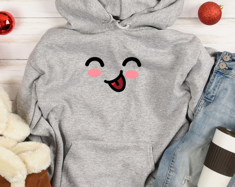 May include: A gray hoodie with a cartoon smiley face with a tongue sticking out. The face has pink cheeks and black eyes.