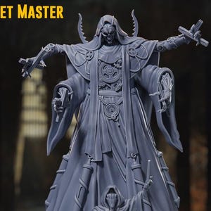 May include: A grey figurine of the Puppet Master, a tall figure with multiple arms holding tools, and a smaller figure at the base. The figurine has the text "PUPPET MASTER LARGE" at the top.