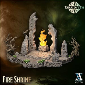 Può includere: Una miniatura dettagliata di un Fire Shrine con una fiamma centrale, circondata da pilastri di pietra usurati e alberi stilizzati. La base è strutturata con piccole piante. Il testo "Fire Shrine" è in basso, con il logo "A Games Digital".