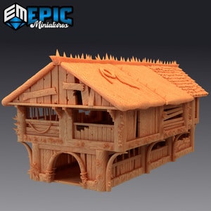 Può includere: Una miniatura marrone chiaro di un fienile rustico a due piani. Il fienile presenta un tetto di paglia, pareti in legno con venature visibili e dettagli architettonici come porte ad arco e finiture decorative. Il testo "EM EPIC Miniatures" è visibile.