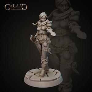 Può includere: Statuetta dettagliata di una guerriera, con due lame ricurve. Indossa un'armatura, una sciarpa e cinture. La figura è su una base di pietra, con un duplicato ombreggiato dietro. La parola "Galaad" è in alto a sinistra.