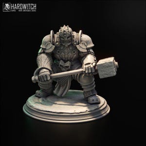 May include: A grey figurine of a warrior in full armour, holding a large hammer. The warrior is kneeling on a circular base. The figurine has intricate details, including a skull on the belt. The Hardwitch Games logo is in the top left corner.