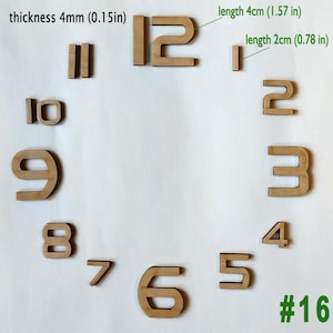 May include: Wooden clock numbers in a light brown color. The numbers are arranged in a circular pattern, with the number 12 at the top. The thickness is 0.15 inches. The number 1 is 1.57 inches long. The number 2 is 0.78 inches long. The number 16 is in green.