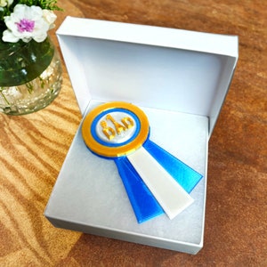 May include: A blue and gold ribbon with the text "#1 Dad" in a white box.